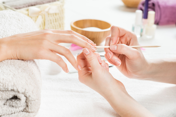 Iemand laat nagelriemen terugduwen tijdens een manicure